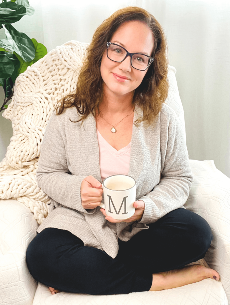 Melissa Ann Chavis sitting cross-legged holding a mug